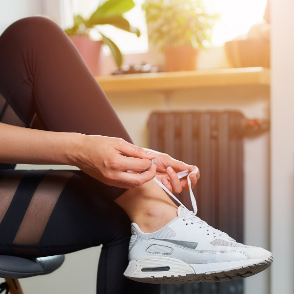 Image of lady doing up fitness shoe lace ready for a workout sharing that excerise can also recharge the batteries