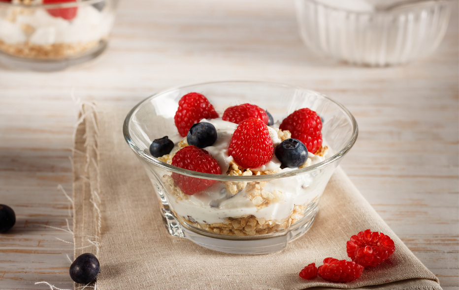 Start your morning right with a healthy, feel good breakfast. Bowl of fruit with yogurt and granola on a napkin