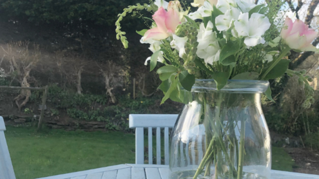sing flowers in a glass vase on an outside table